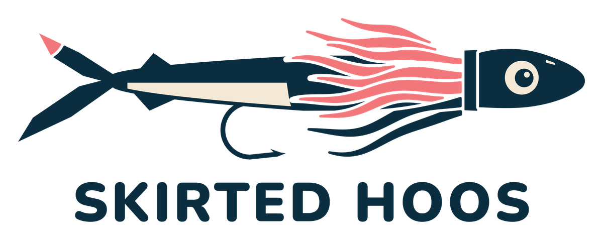 Skirted Hoos logo: a skirted lure with coral and navy strands rigged over a navy ballyhoo, above the words Skirted Hoos.